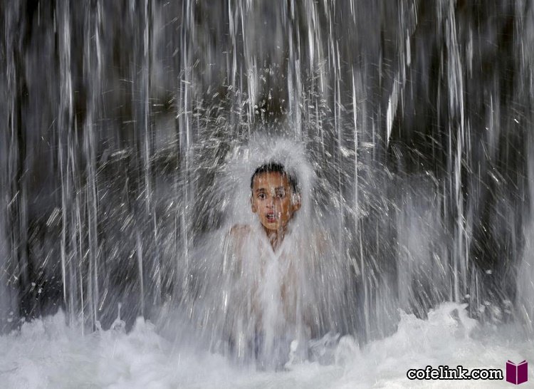 پسری روز ۲۵ اوت (۳ شهریور) ۲۰۱۵ زیر آبشاری در کابل پایتخت افعانستان خود را خنک می‌کند.